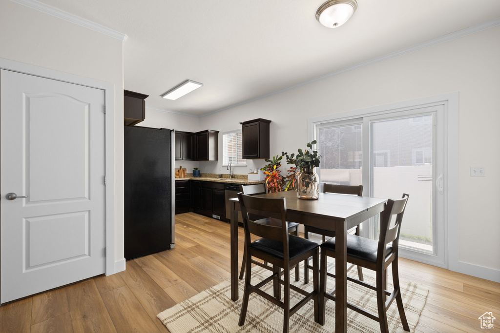Dining space featuring ornamental molding and light wood-type flooring