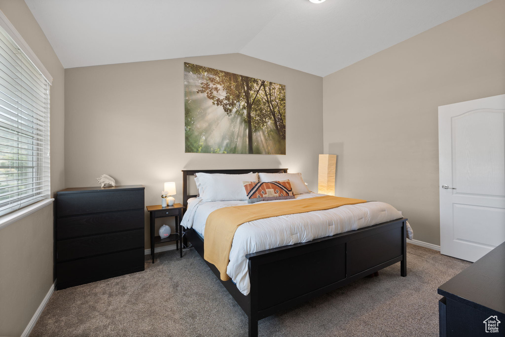 Bedroom featuring lofted ceiling and carpet flooring