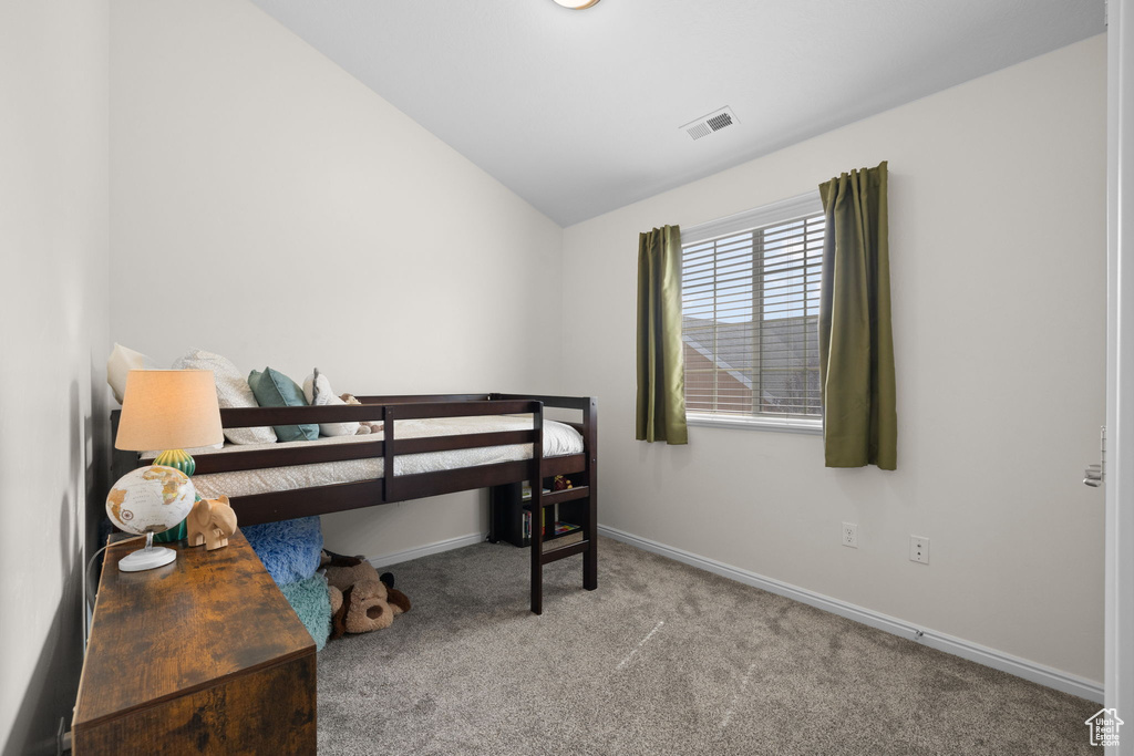Bedroom with carpet flooring and vaulted ceiling