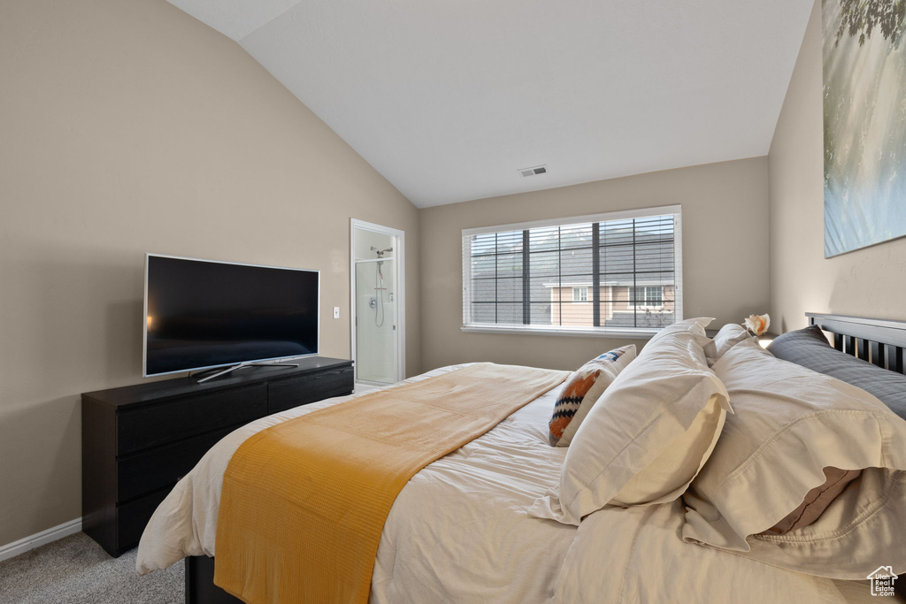 Bedroom featuring lofted ceiling and light colored carpet