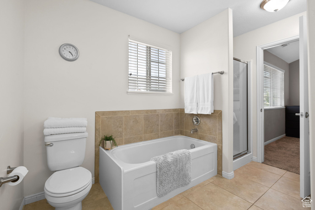 Bathroom with healthy amount of natural light, a garden tub, tile patterned floors, and a stall shower