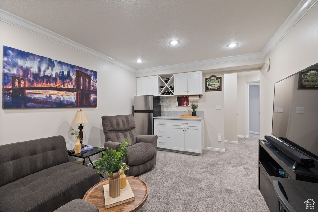 Living room featuring bar with sink, crown molding, light colored carpet, and recessed lighting