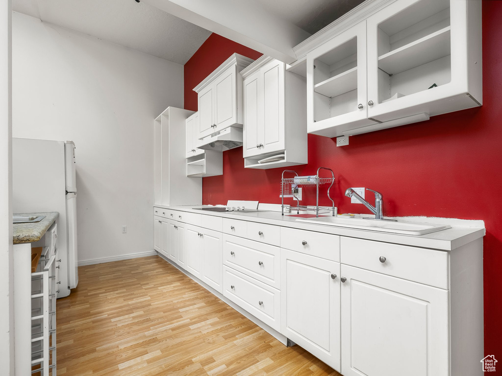 Kitchen featuring white cabinetry, light countertops, and light wood-type flooring