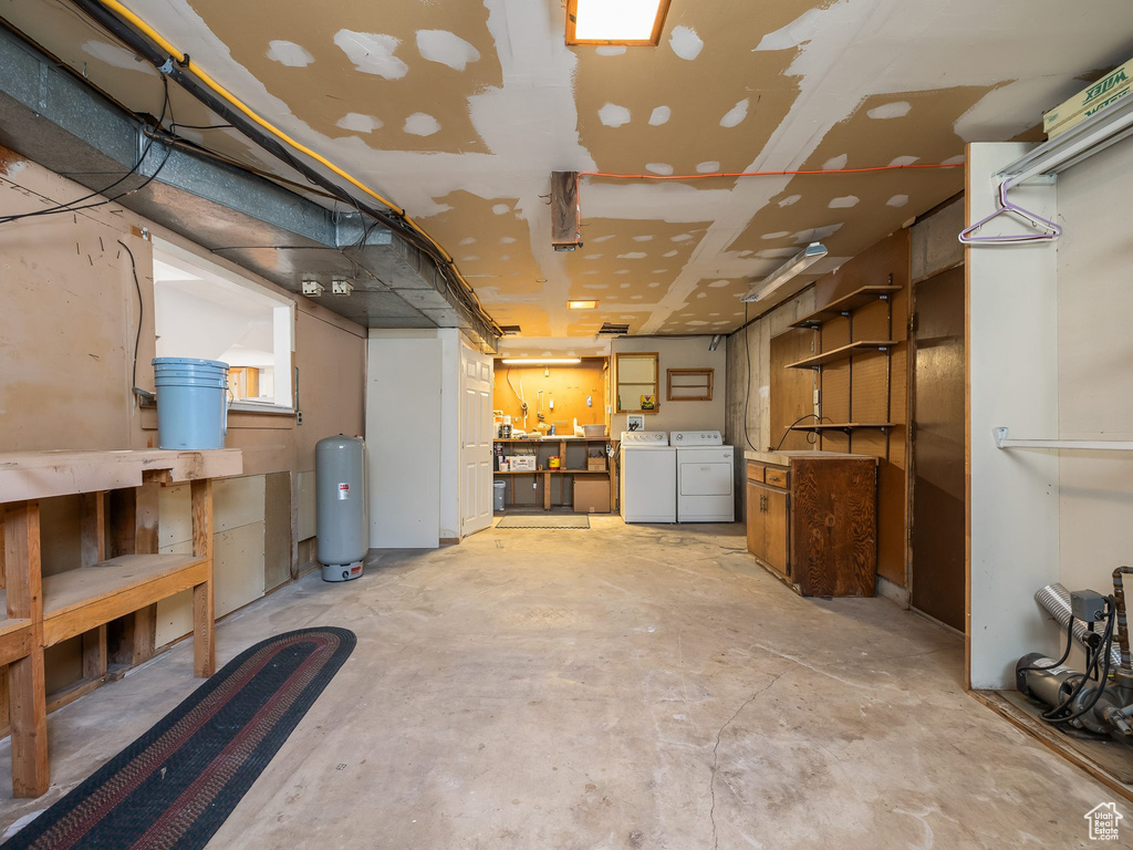 Basement with washing machine and dryer and a water pressure tank