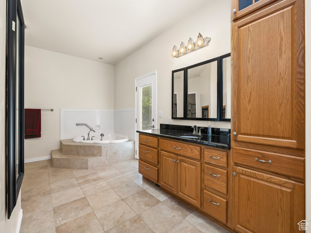 Full bath with a garden tub, vanity, and tile patterned floors