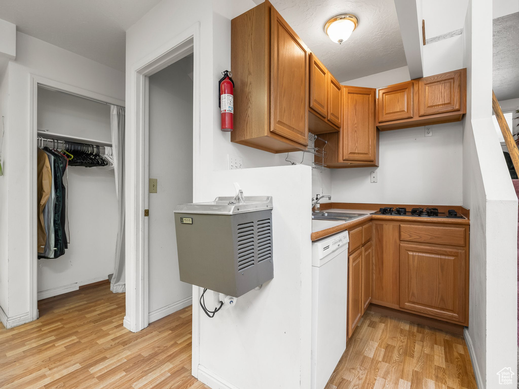 Kitchen featuring dishwasher, light wood-style floors, black gas stovetop, and brown cabinetry