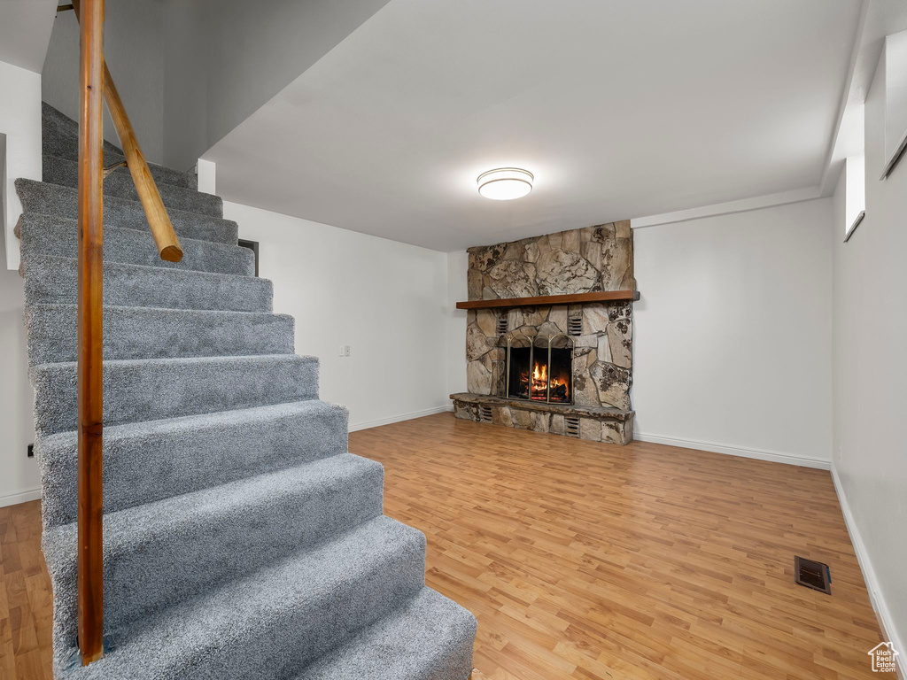 Living room with stairway, wood finished floors, and a fireplace