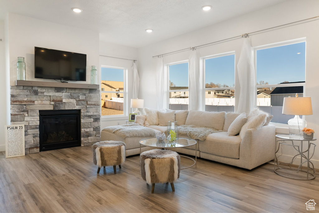 Living room with wood finished floors, healthy amount of natural light, a fireplace, and recessed lighting