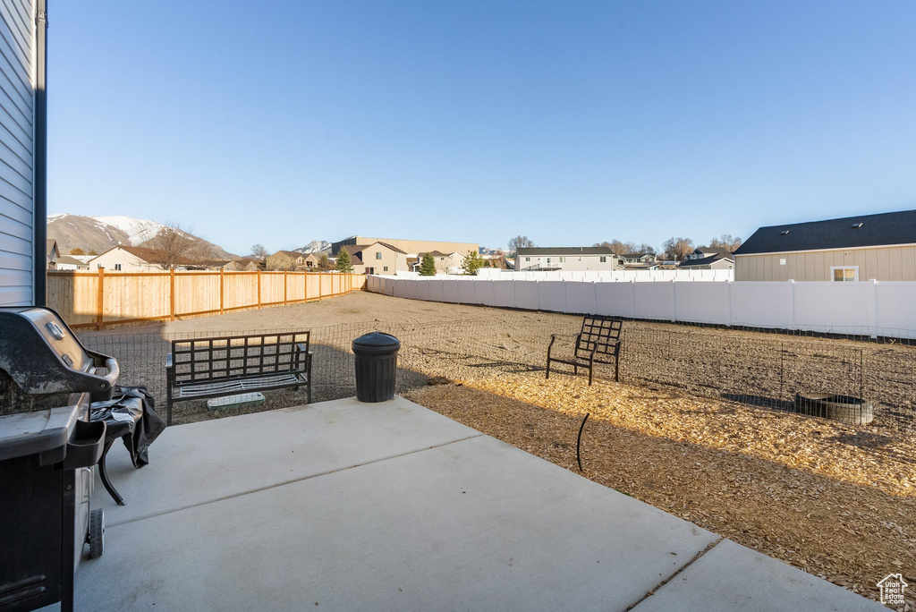 Fenced backyard with a patio area, grilling area, and a residential view