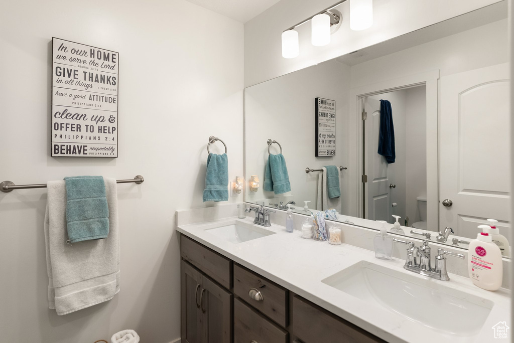 Full bath with double vanity and toilet