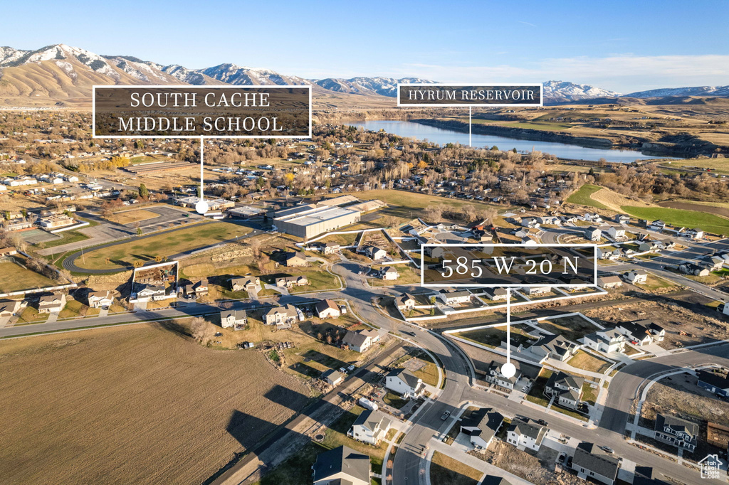 Aerial view of property and surrounding area featuring a water and mountain view