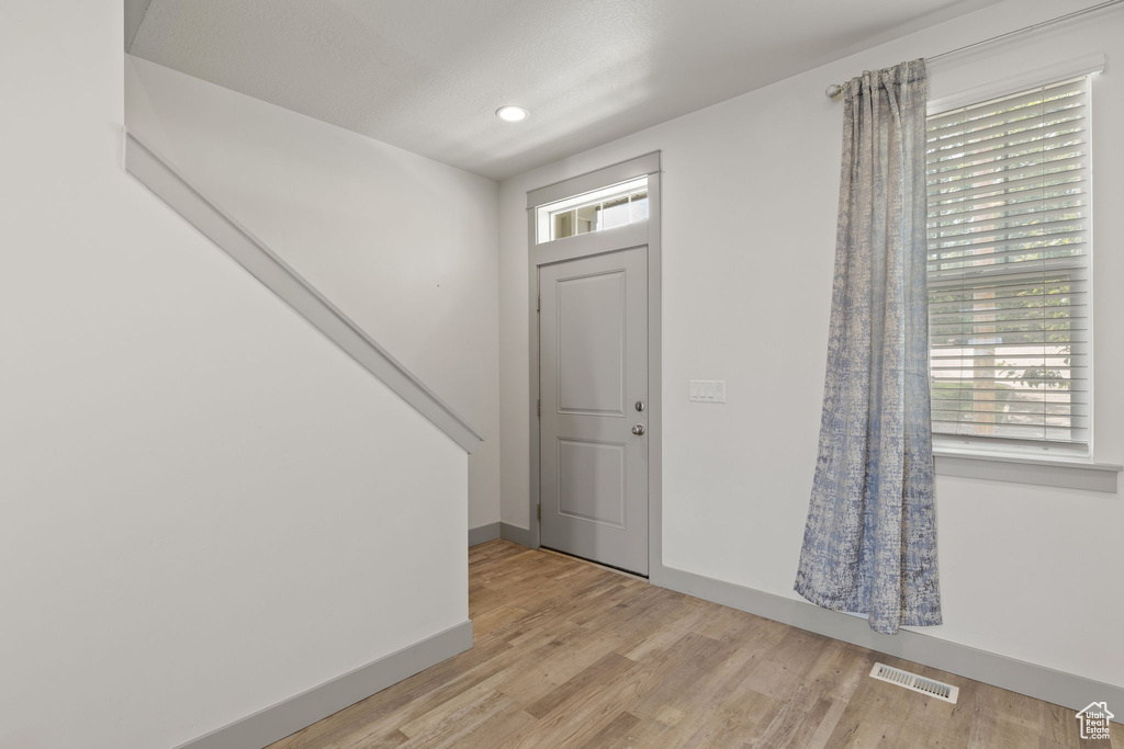 Foyer with healthy amount of natural light, light wood-type flooring, and recessed lighting