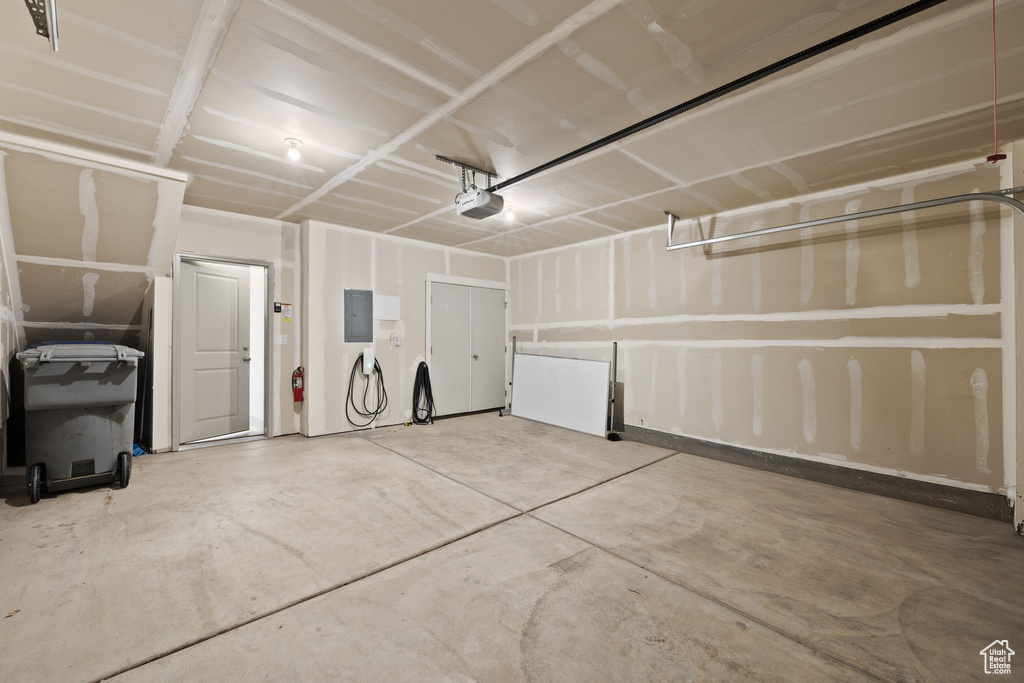 Garage featuring electric panel and a garage door opener