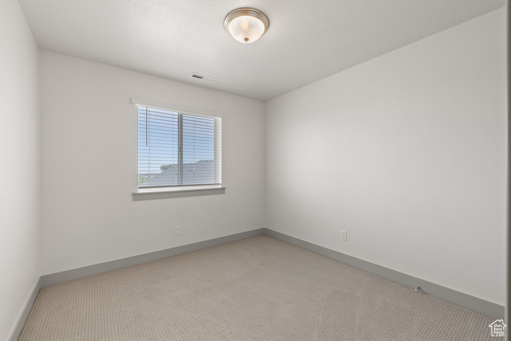 Unfurnished room with light carpet and baseboards