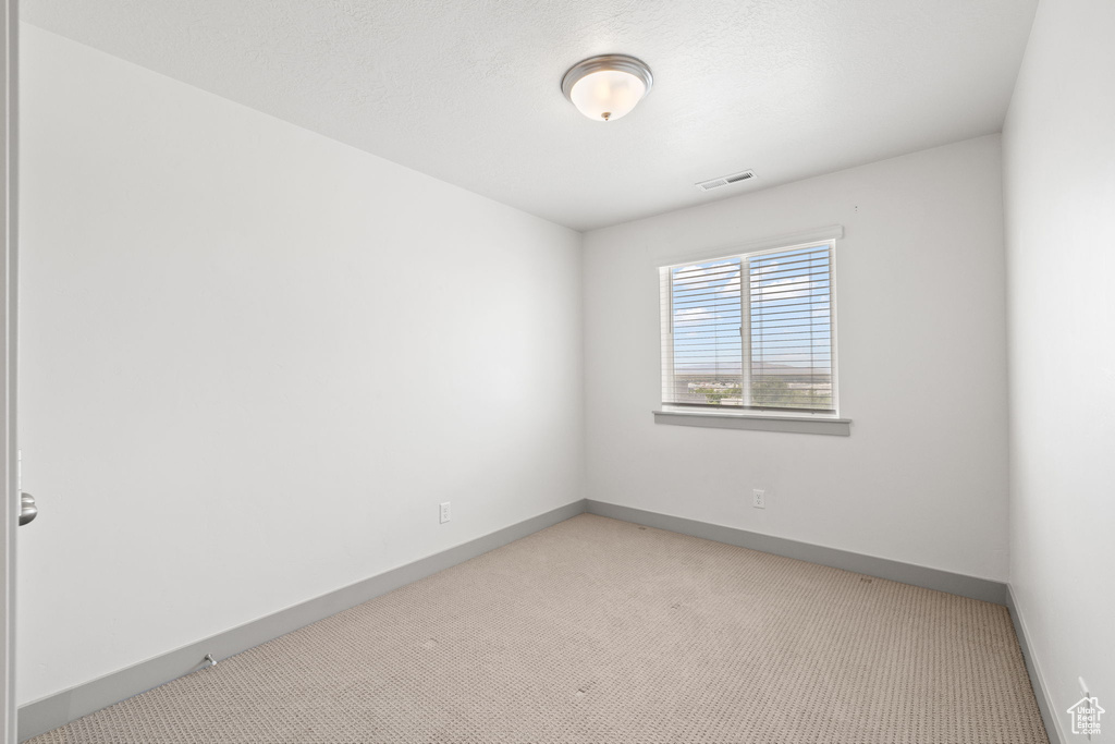Carpeted empty room featuring baseboards