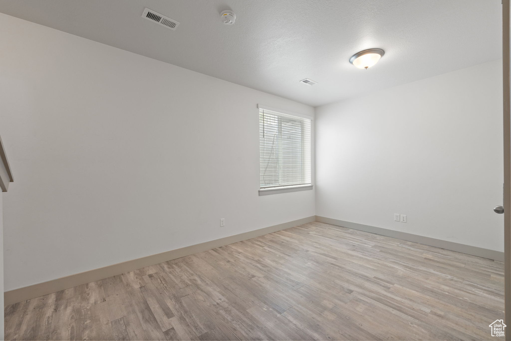 Spare room with light wood finished floors and a smoke detector