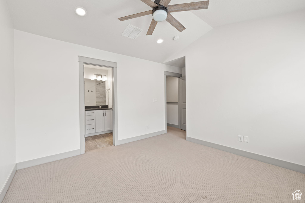 Unfurnished bedroom featuring light carpet, lofted ceiling, recessed lighting, ensuite bath, and a ceiling fan