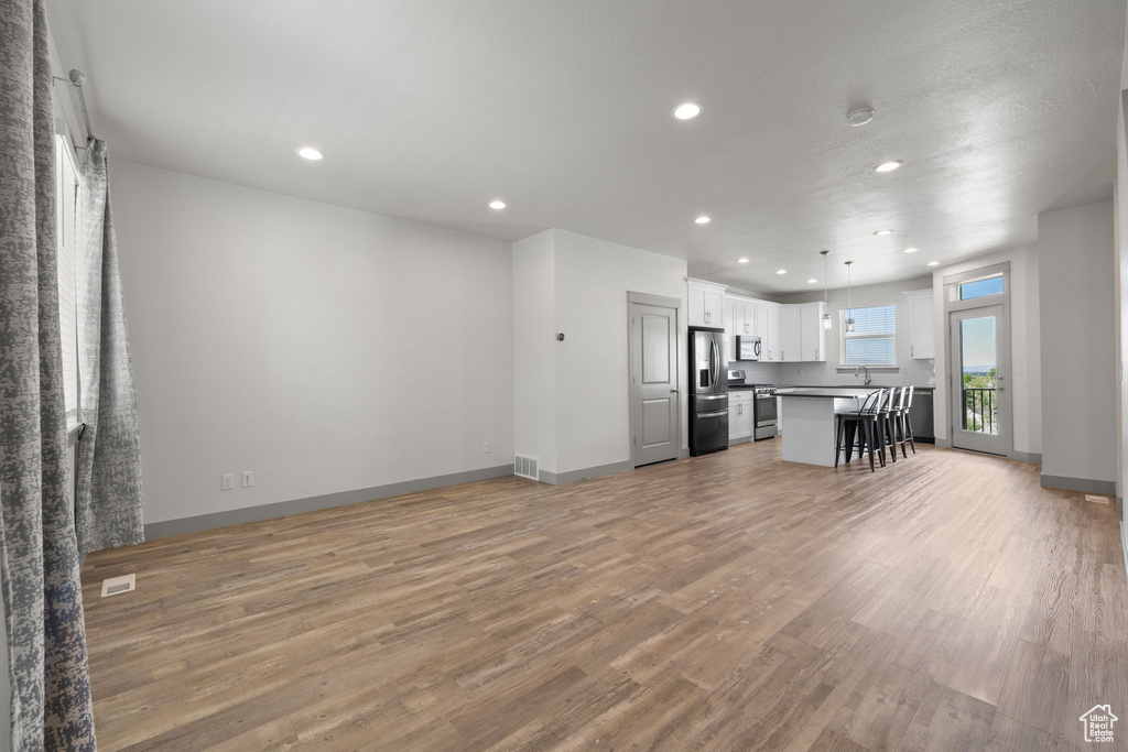 Living room featuring light wood-style flooring and recessed lighting