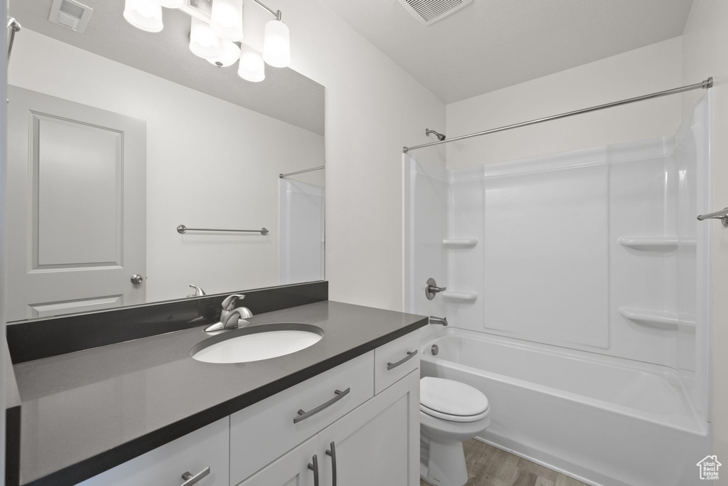 Bathroom with vanity, wood finished floors, and bathtub / shower combination
