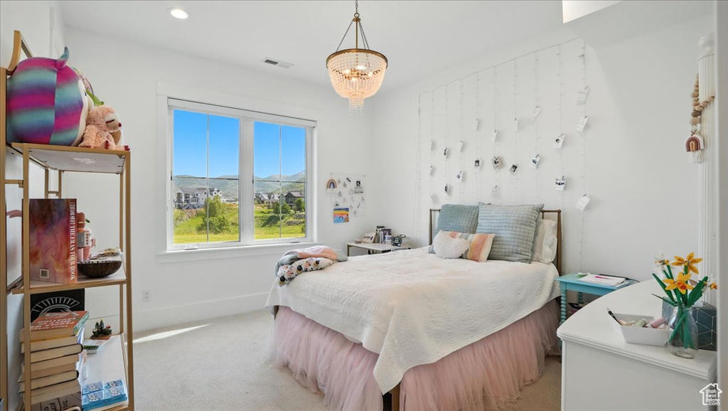 Carpeted bedroom featuring a chandelier and recessed lighting