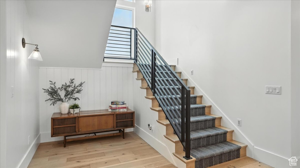 Stairway with wood finished floors and wainscoting