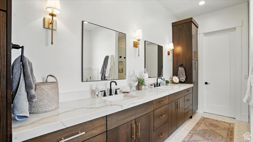 Bathroom with double vanity, tile patterned floors, and recessed lighting