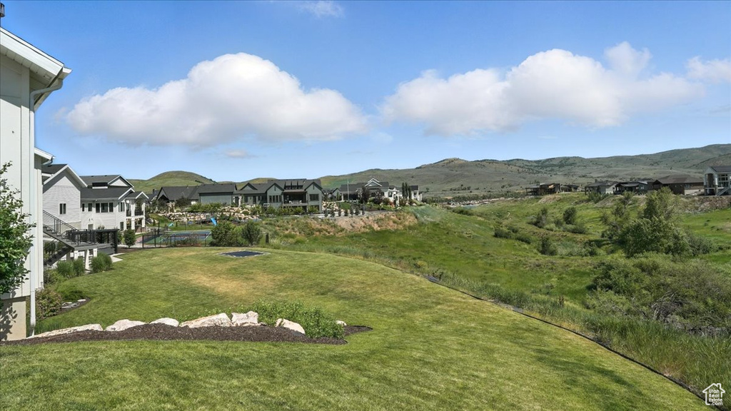 View of green lawn featuring a residential view and a mountain view