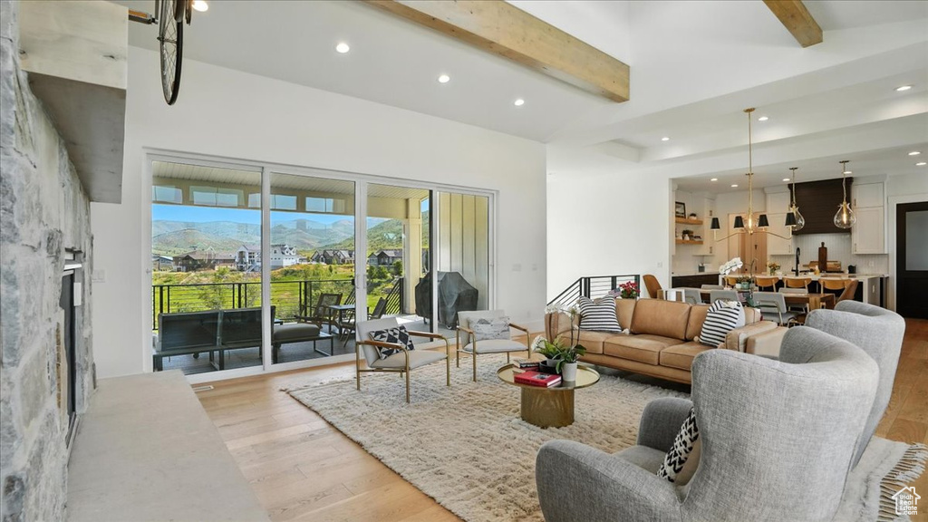 Living room featuring light wood-style floors, beam ceiling, and recessed lighting