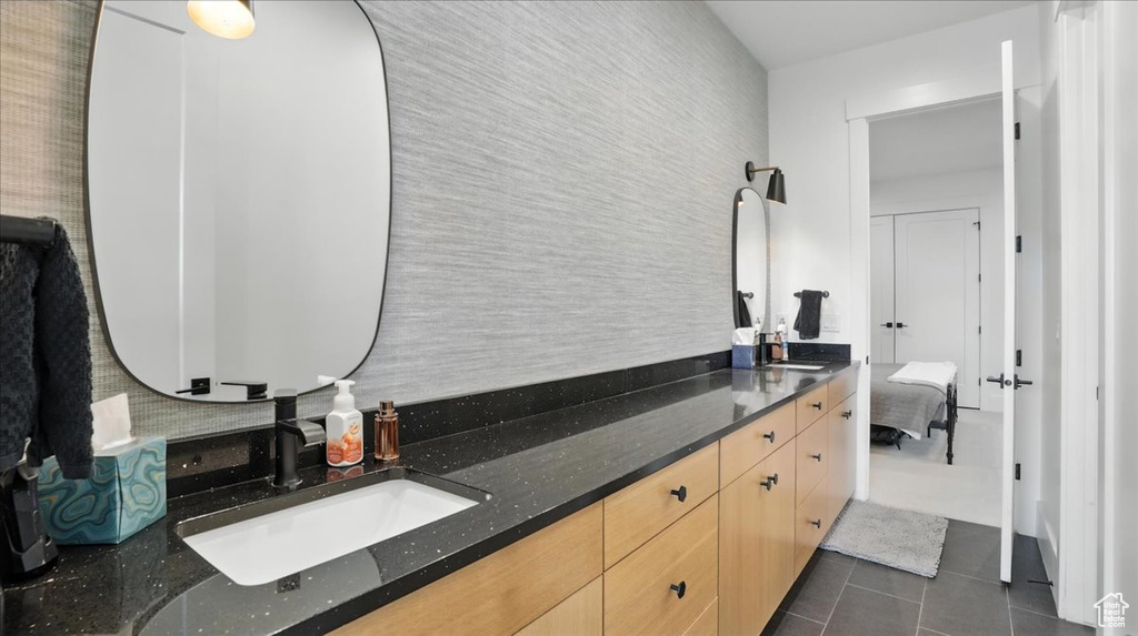 Bathroom with tile patterned flooring, double vanity, and connected bathroom
