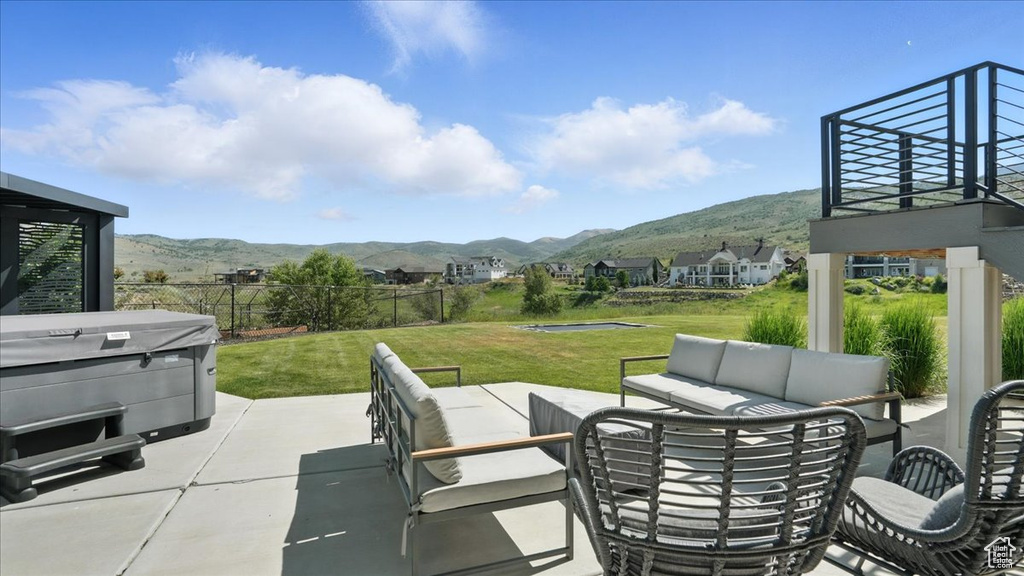 View of patio featuring a mountain view, a hot tub, and an outdoor living space