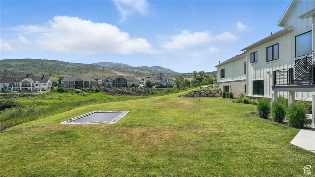 View of grassy yard featuring a mountain view and a residential view