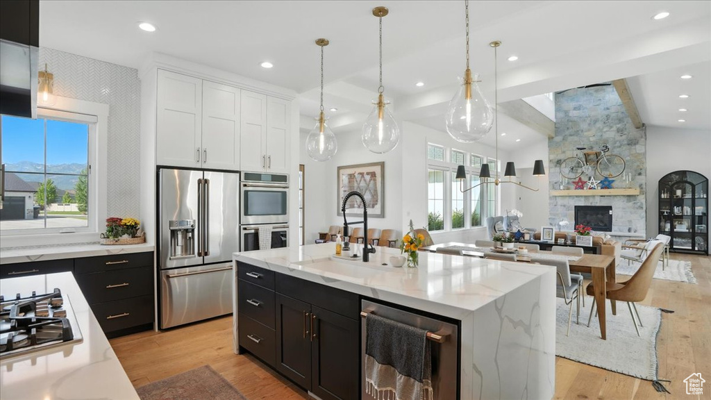 Kitchen featuring stainless steel appliances, dark cabinets, open floor plan, white cabinets, and recessed lighting