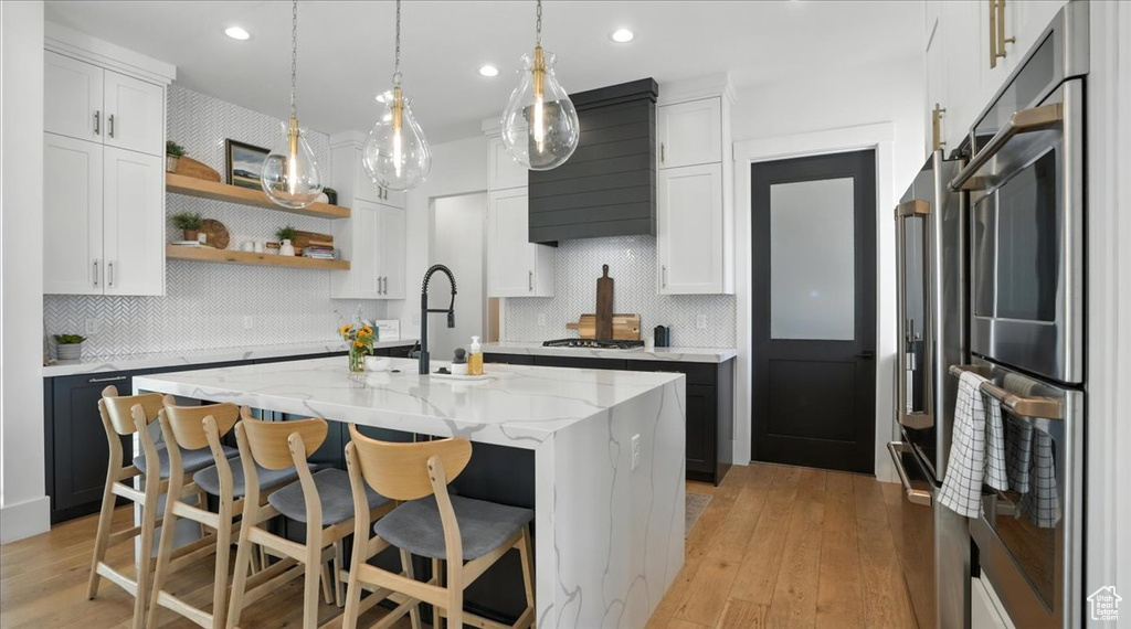 Kitchen featuring open shelves, stainless steel appliances, decorative backsplash, white cabinets, and recessed lighting