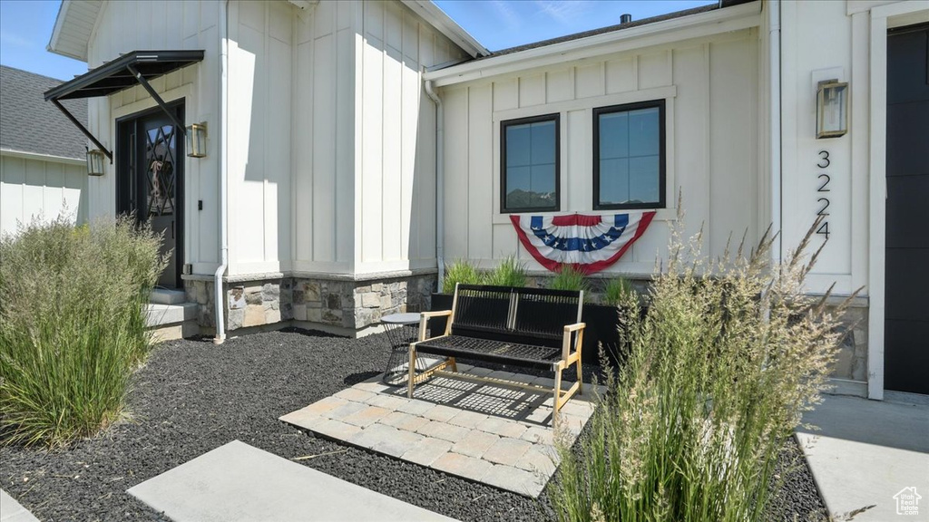 Property entrance with board and batten siding and stone siding