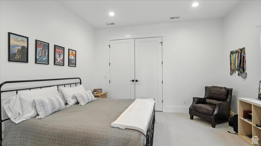 Bedroom featuring light colored carpet, a closet, and recessed lighting