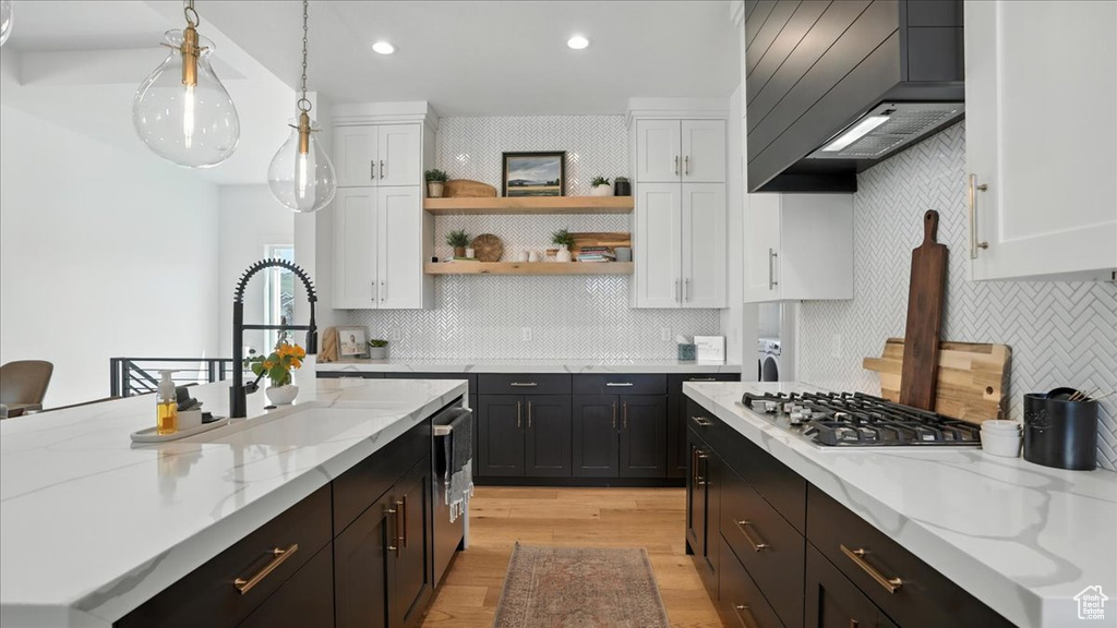 Kitchen with stainless steel gas stovetop, premium range hood, white cabinetry, and recessed lighting