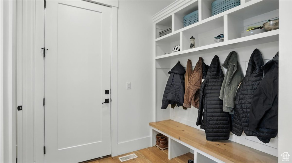 Mudroom featuring light wood-style flooring and baseboards