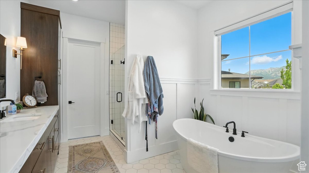 Full bathroom featuring a shower stall, a freestanding tub, double vanity, a mountain view, and tile patterned flooring
