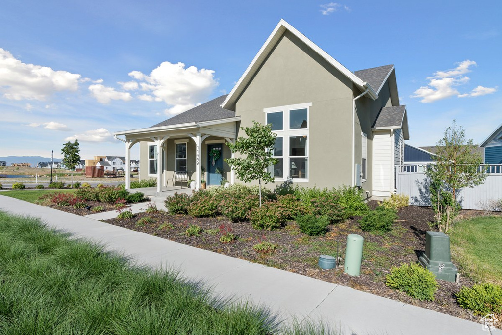 View of front facade with a porch and stucco siding