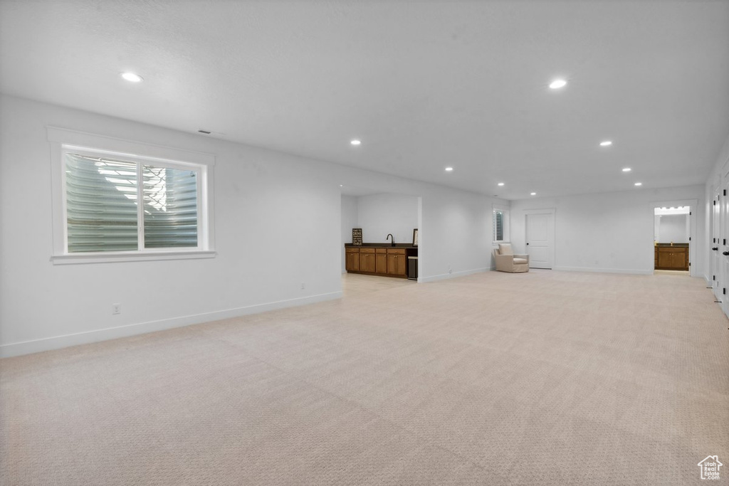 Unfurnished living room with recessed lighting and light carpet