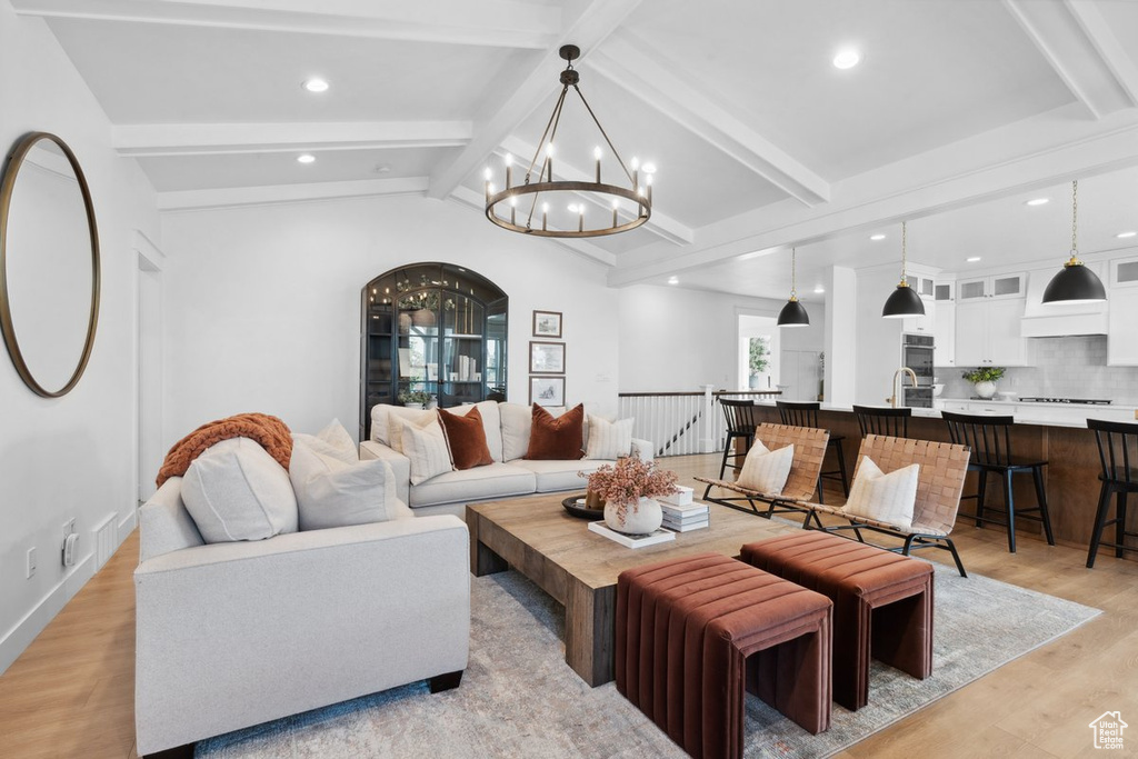 Living room featuring a chandelier, light wood-style flooring, and recessed lighting