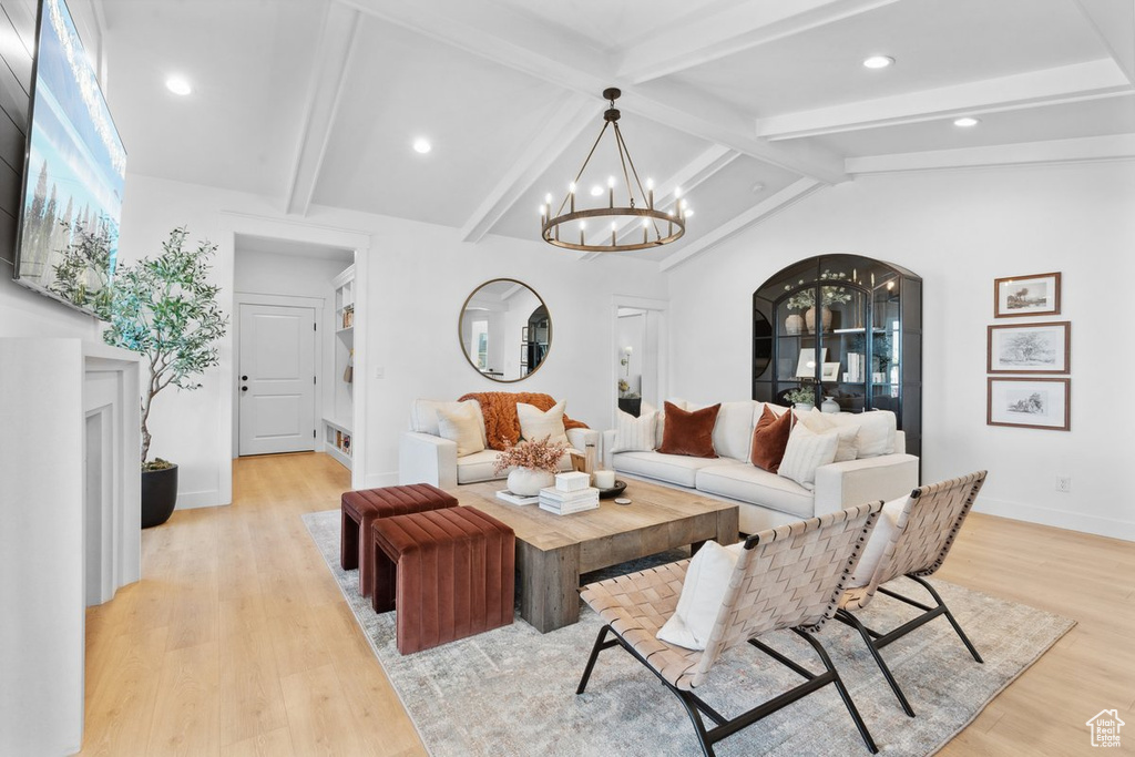 Living room featuring a chandelier, light wood-style floors, recessed lighting, and arched walkways