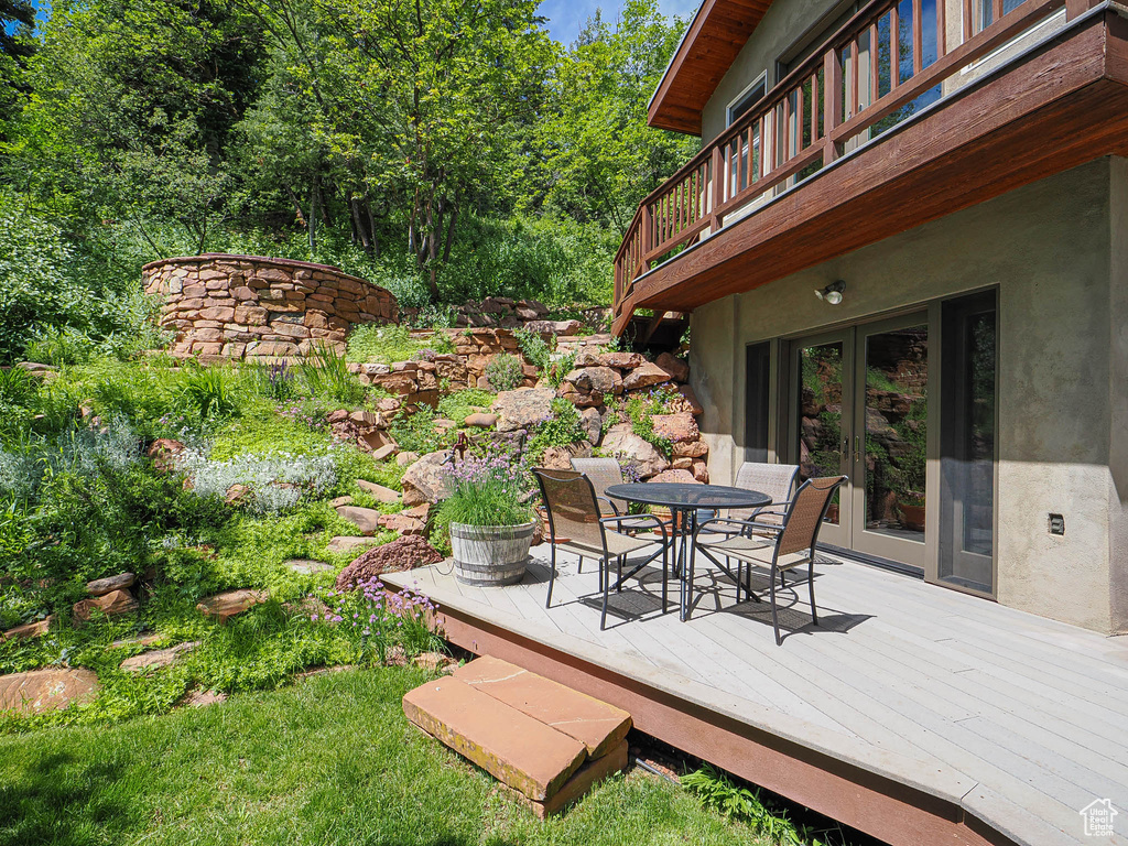 Wooden terrace featuring french doors and outdoor dining area
