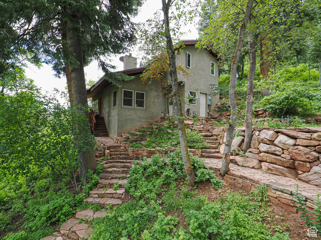 Back of house featuring stairs and stucco siding