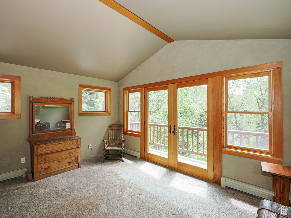 Living area with a baseboard radiator, vaulted ceiling, french doors, carpet floors, and a baseboard heating unit