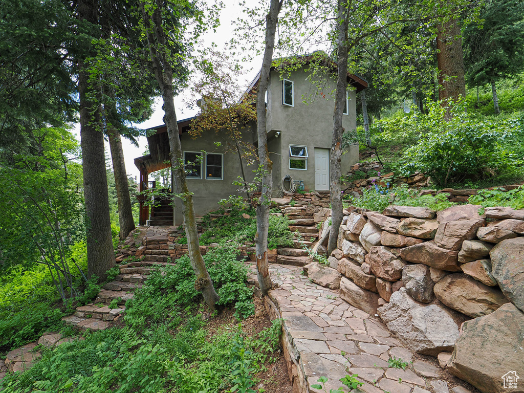 Back of property featuring stairway and stucco siding