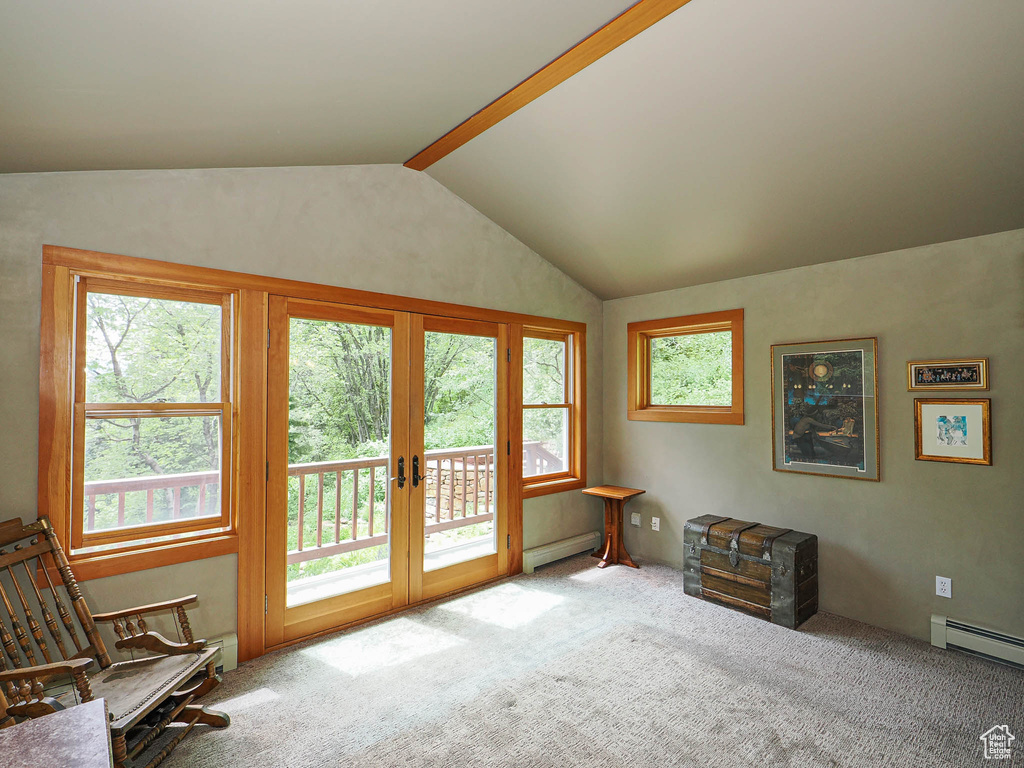 Living area featuring a baseboard radiator, vaulted ceiling, carpet floors, and french doors