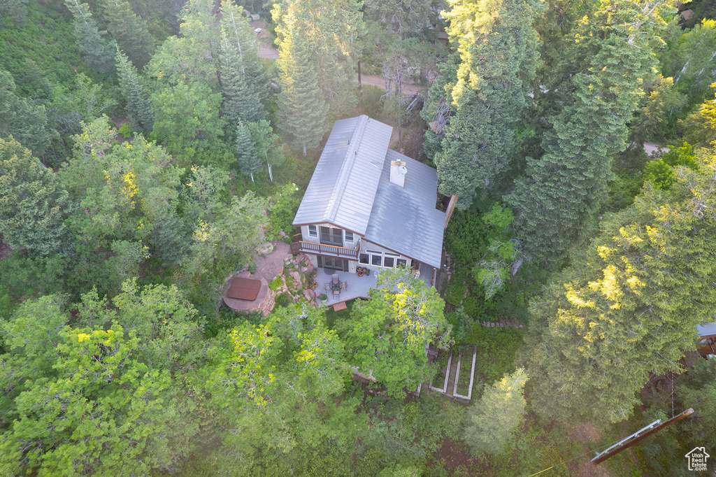 Aerial view of property and surrounding area with a heavily wooded area