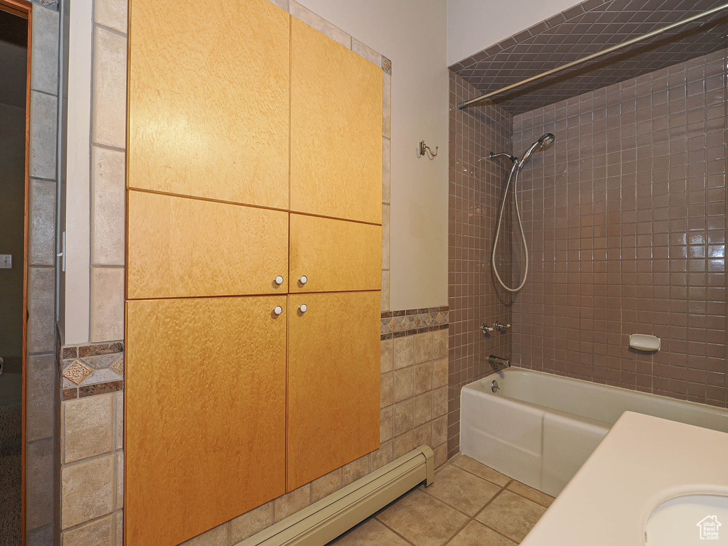 Full bathroom featuring shower / tub combination, tile patterned floors, a wainscoted wall, and tile walls