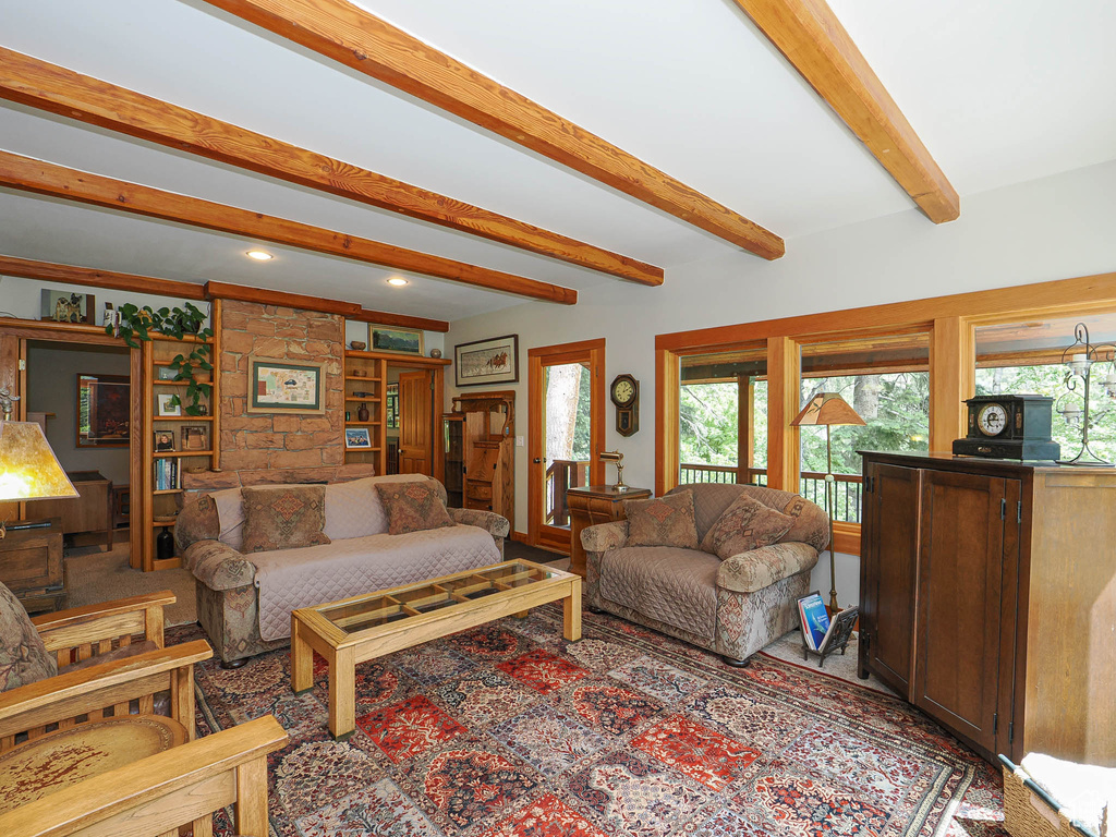 Living area featuring healthy amount of natural light and beamed ceiling